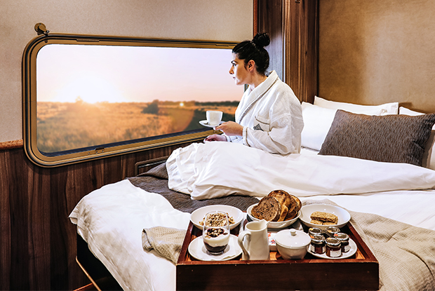 lady enjoying the view from her cabin window onboard The Ghan